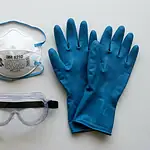Rodent cleanup safety gear including N95 respirator mask, heavy nitrile gloves, eye goggles, and disinfectant